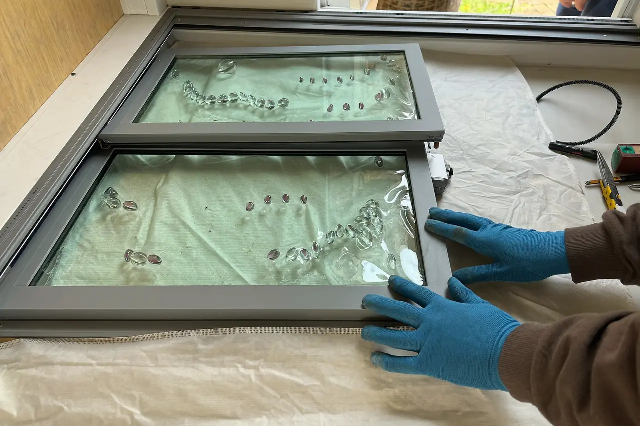 Installer fitting a replacement sealed glass unit into a window frame